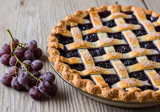 A delicious-looking grape pie from Naples, with a golden lattice crust and rich purple filling.