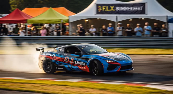 A sleek pace car speeding around the Watkins Glen racetrack during the F.L.X. Summer Fest, with festival tents visible in the infield.